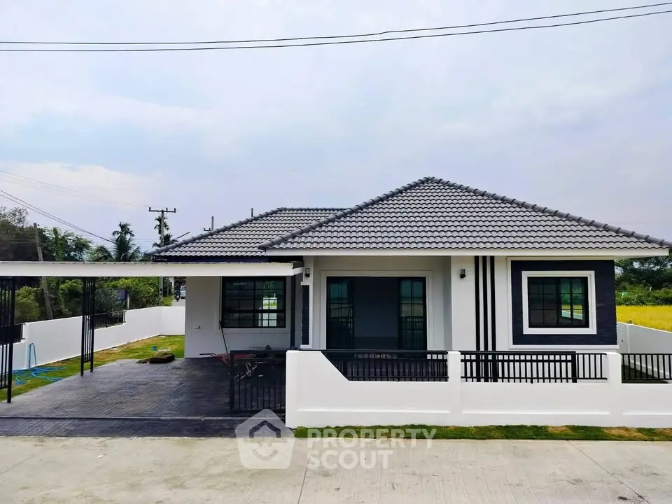Modern single-story house with spacious driveway and stylish roof design.