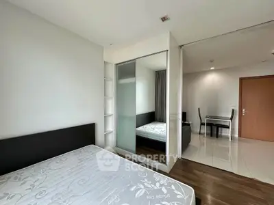Modern bedroom with mirrored closet and dining area in a stylish apartment