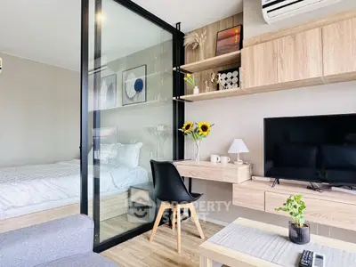 Modern studio apartment with glass partition, cozy bedroom, and stylish living area.