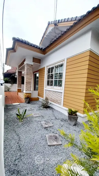 Charming single-story home with modern exterior and landscaped front yard.