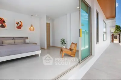 Modern bedroom with sliding glass doors opening to a spacious balcony, featuring stylish decor and natural light.