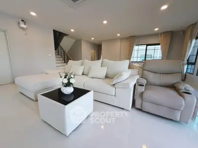 Spacious modern living room with elegant white sofa and cozy recliner, perfect for relaxation and entertainment.