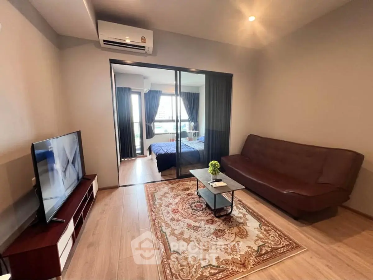 Modern living room with stylish decor and view into cozy bedroom