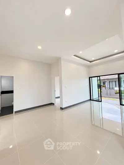 Spacious modern living room with large windows and sleek tile flooring