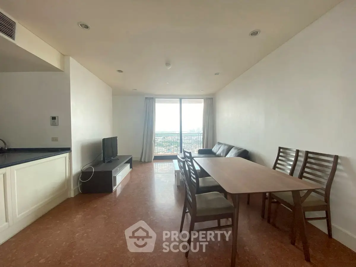 Spacious living room with dining area and balcony view in modern apartment.