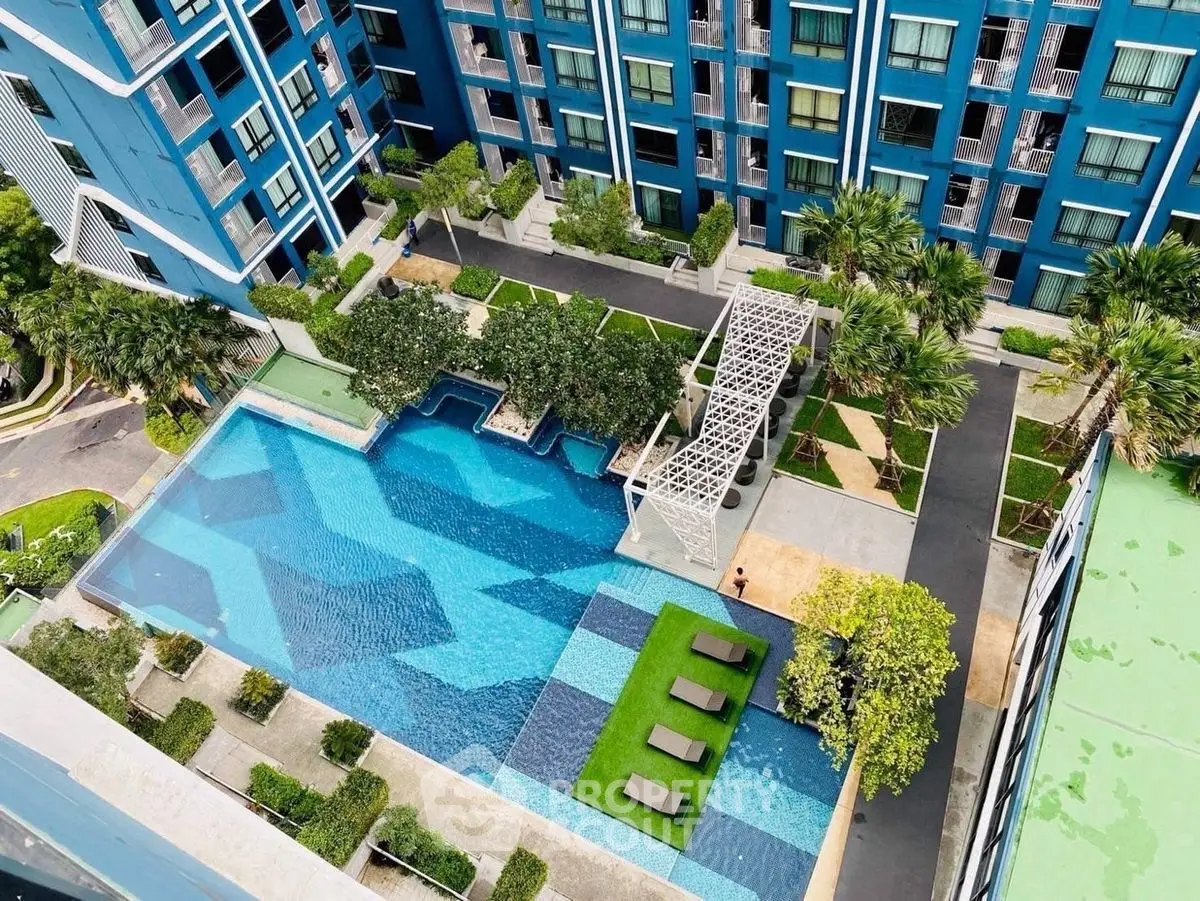 Stunning aerial view of modern apartment complex with luxurious swimming pool and lush landscaping.