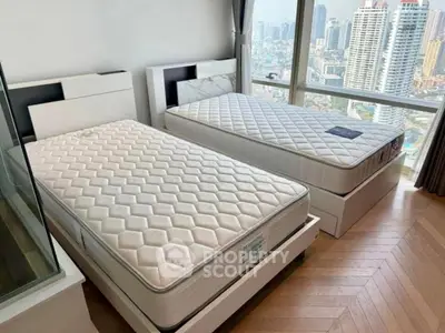 Spacious bedroom with twin beds and stunning city view from large window