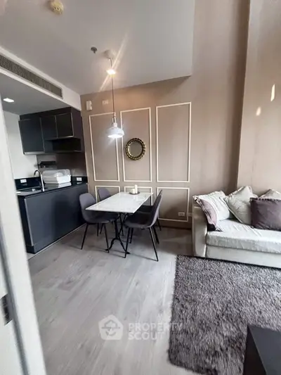 Modern living room with open kitchen, stylish decor, and cozy seating area in a contemporary apartment.