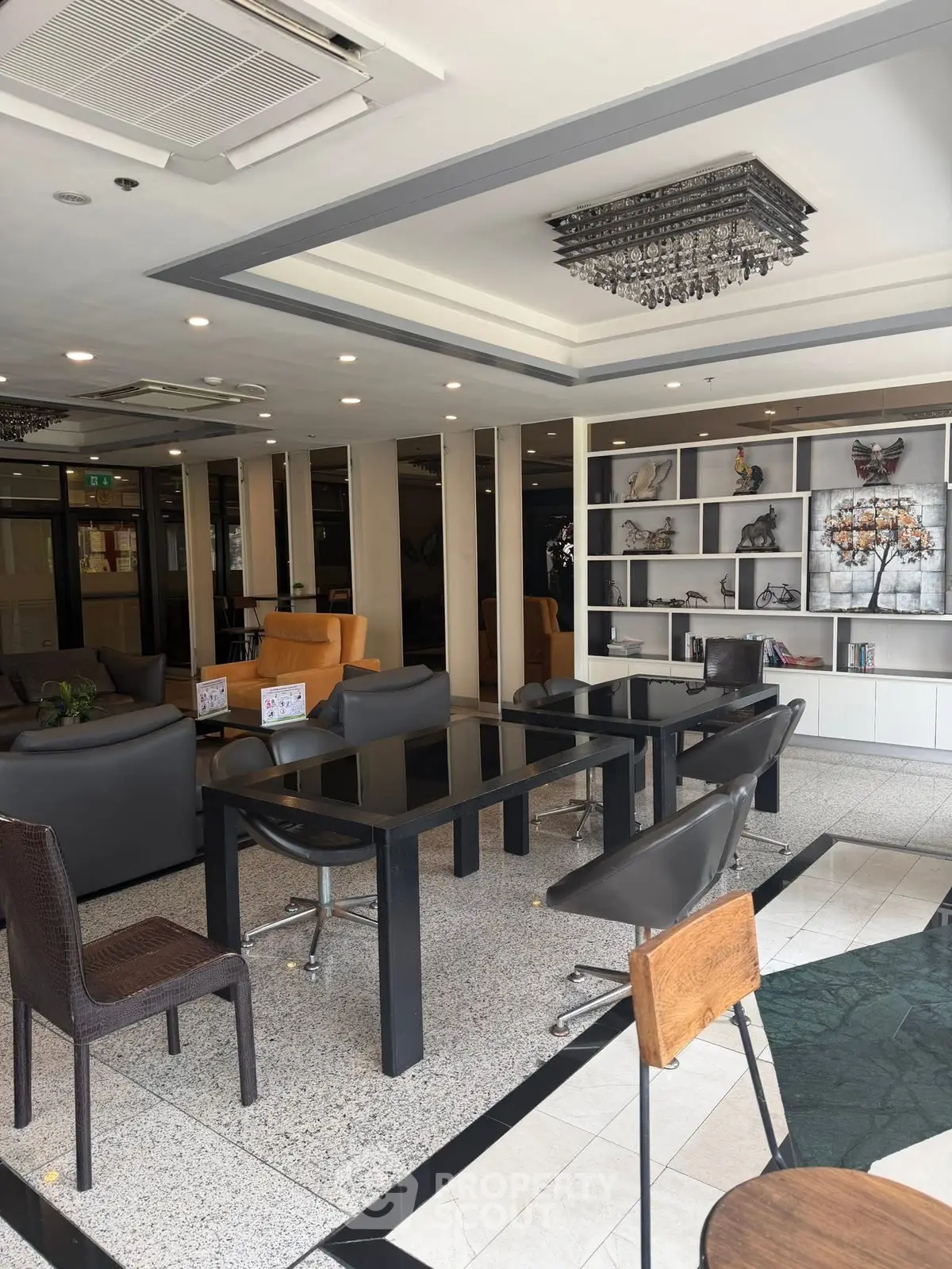 Modern lobby with stylish seating and decorative shelves in a contemporary building.