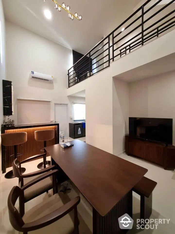 Modern loft-style living room with high ceiling and elegant wooden furniture