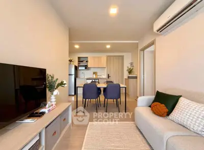 Modern living room with open kitchen, stylish decor, and cozy seating area in a contemporary apartment.