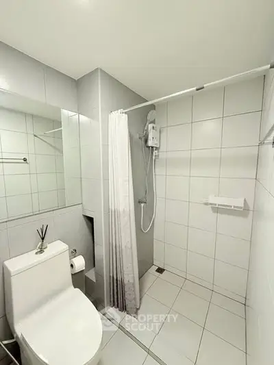Modern bathroom with sleek white tiles and shower area