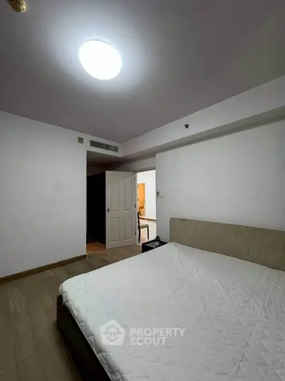 Spacious bedroom with modern design and cozy ambiance, featuring a comfortable bed and stylish lighting.