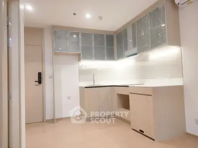 Modern kitchen with sleek cabinetry and ample lighting in a contemporary apartment.