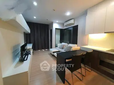 Modern living room with open kitchen and stylish decor in a cozy apartment.