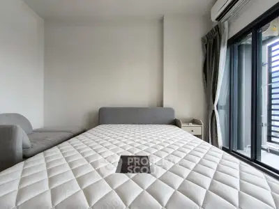 Modern bedroom with large window and comfortable bed in urban apartment