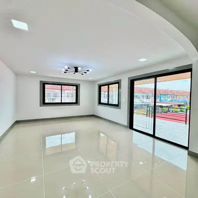 Spacious modern living room with large windows and glossy tiled floor