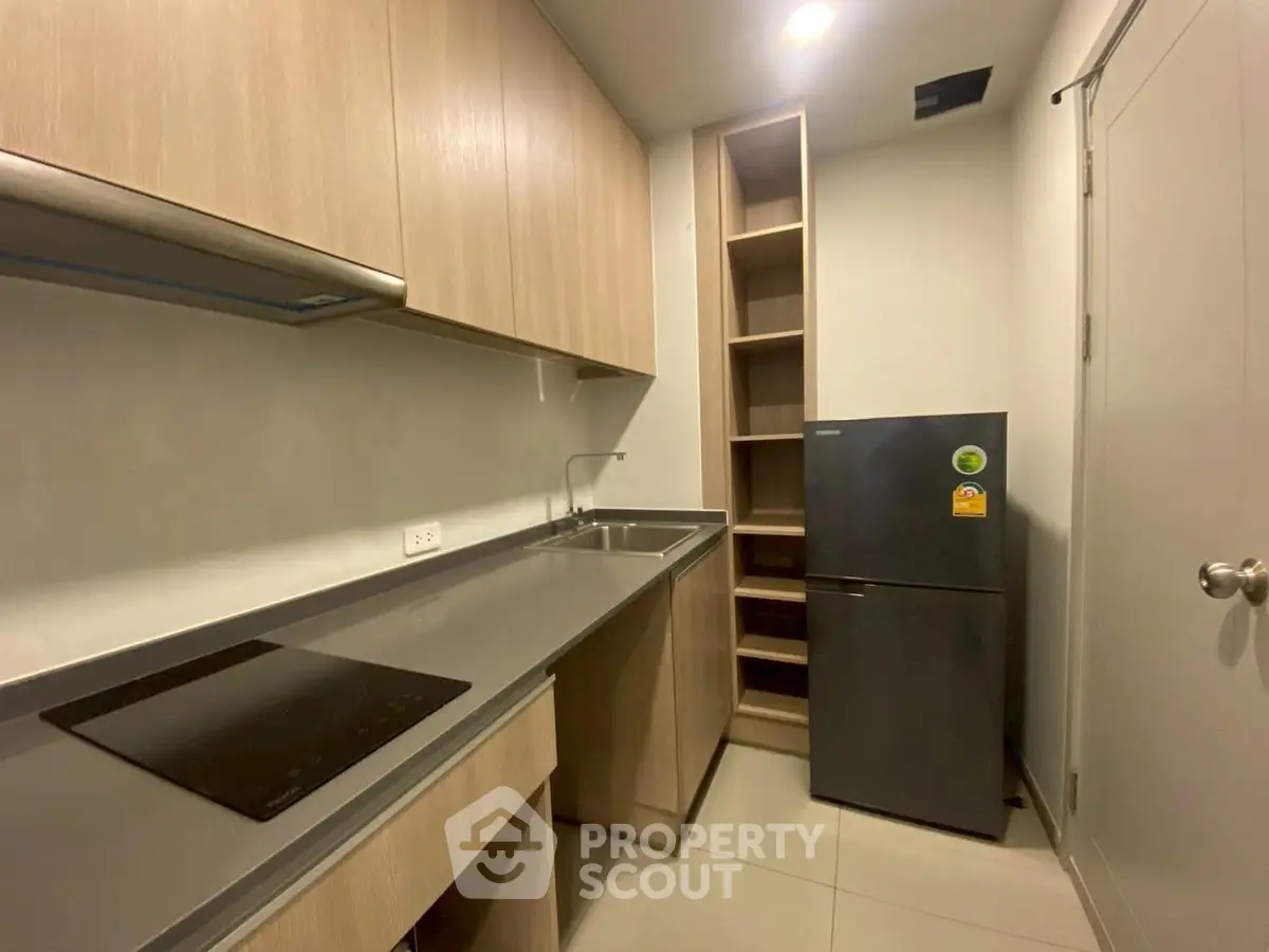 Modern kitchen with sleek cabinetry and compact fridge in a cozy layout.
