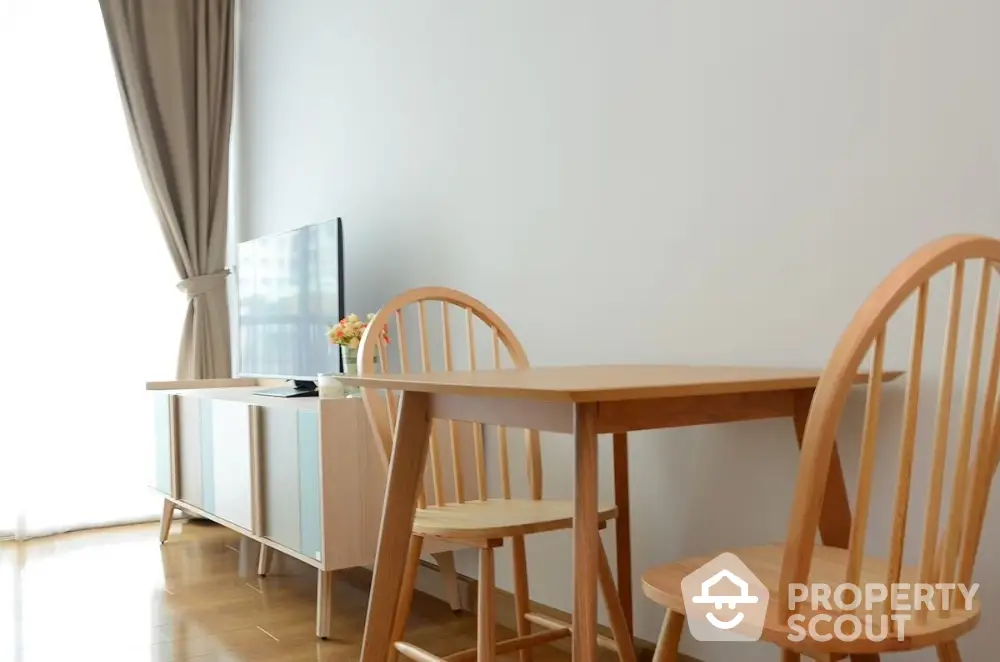 Modern living room with wooden dining set and TV stand, bright natural light