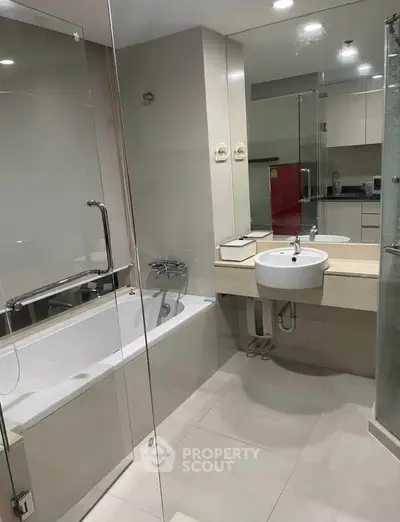 Modern bathroom with glass shower and sleek fixtures in a contemporary apartment.