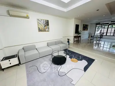 Spacious modern living room with stylish decor and ample natural light.