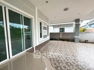 Spacious covered patio area with tiled flooring and sliding glass doors