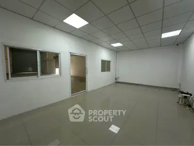 Spacious office space with tiled flooring and modern lighting