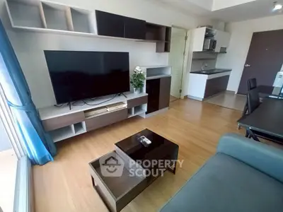 Modern living room with sleek furniture and open kitchen layout in a stylish apartment.