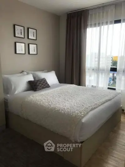 Cozy bedroom with plush bedding and natural light in modern apartment