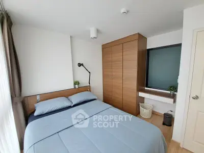 Modern bedroom with wooden wardrobe and cozy bedding in a bright apartment.