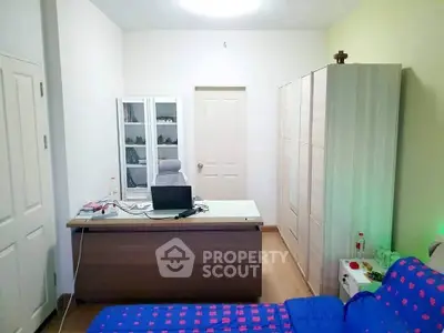 Cozy study room with desk, chair, and ample storage in modern apartment.