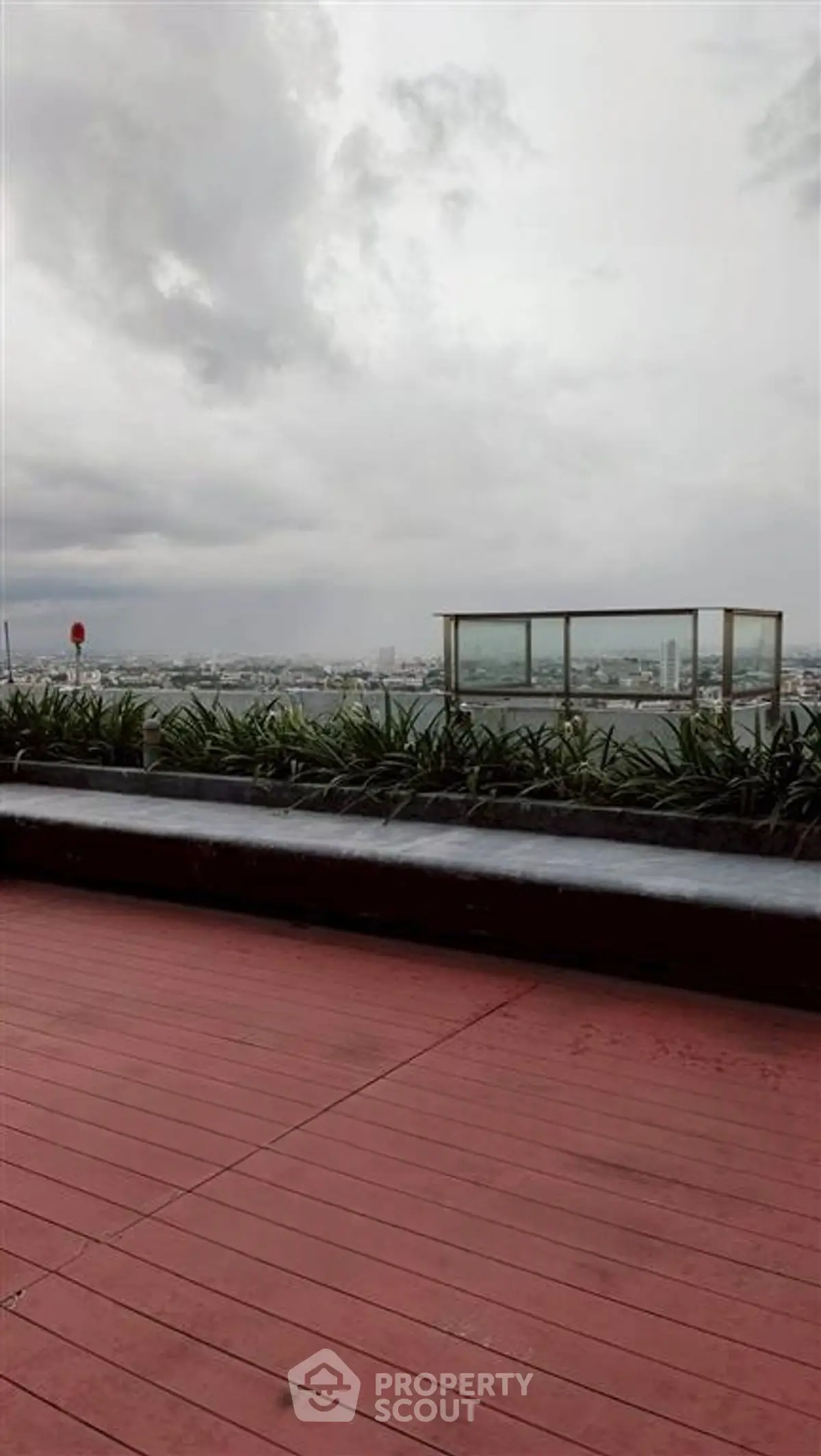 Stunning rooftop view with modern glass railing and lush greenery