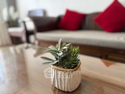 Stylish living room with modern decor and elegant furniture, featuring a chic potted plant centerpiece.