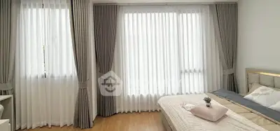 Bright and airy bedroom with elegant curtains and cozy bedding