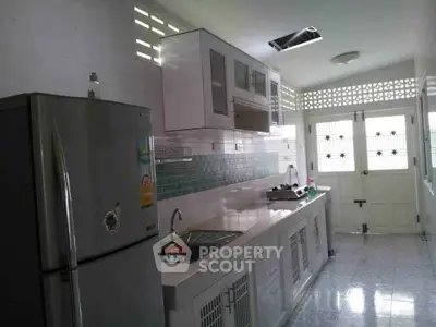 Modern kitchen with sleek cabinets and stainless steel fridge in bright interior.
