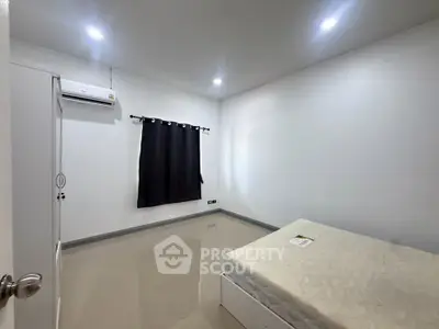Minimalist bedroom with air conditioning and simple decor, perfect for a cozy retreat.