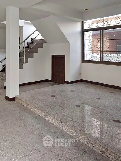 Spacious interior with elegant staircase and large window, perfect for modern living.