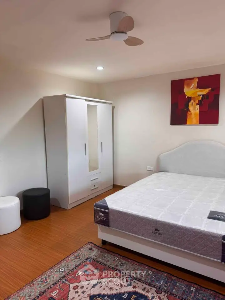 Spacious bedroom with modern decor and ample storage in a stylish apartment.