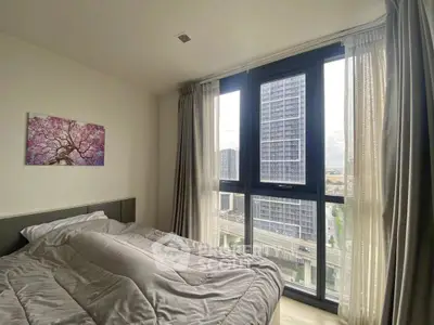 Modern bedroom with large window offering city view and stylish decor.