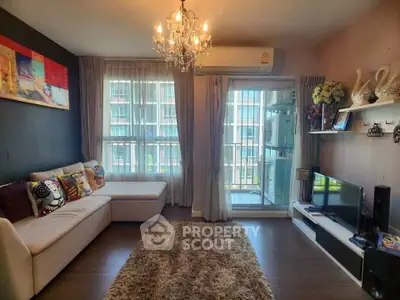 Stylish living room with chandelier, cozy sofa, and balcony view in modern apartment.