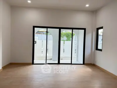 Spacious modern living room with large sliding glass doors and natural light.