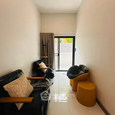 Cozy living room with modern furniture and natural light from balcony.