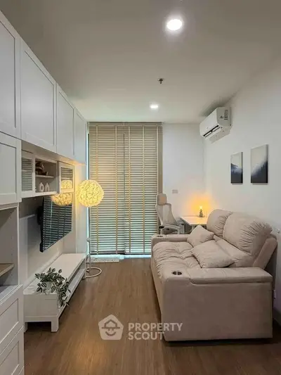 Modern living room with cozy sofa, stylish lighting, and sleek wooden flooring.