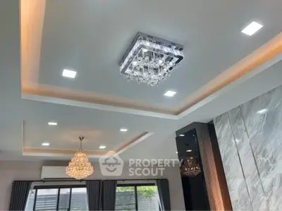 Luxurious living room with elegant chandeliers and modern ceiling design