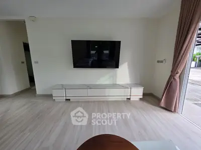 Modern living room with wall-mounted TV and sleek furniture