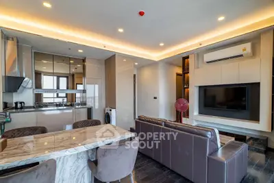 Luxurious modern living room with open kitchen, marble dining table, and sleek furniture.