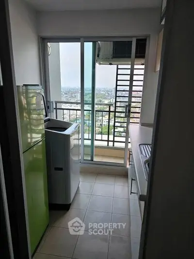 Compact kitchen with balcony view, featuring modern appliances and sleek design.