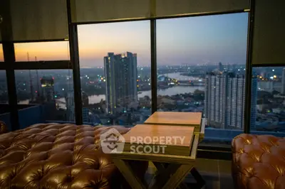 Luxurious living room with stunning city skyline view at sunset.