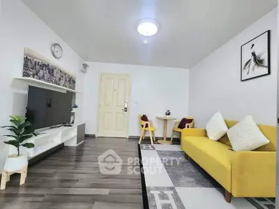 Modern living room with yellow sofa, TV, and stylish decor