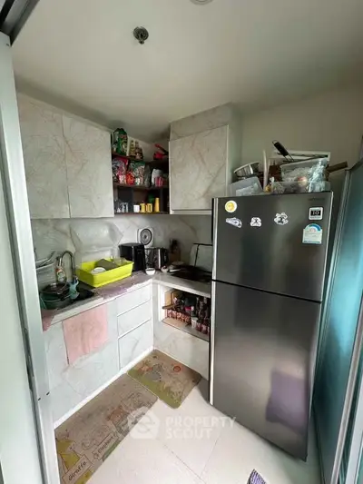 Cozy kitchen with modern fridge and ample storage space, perfect for urban living.